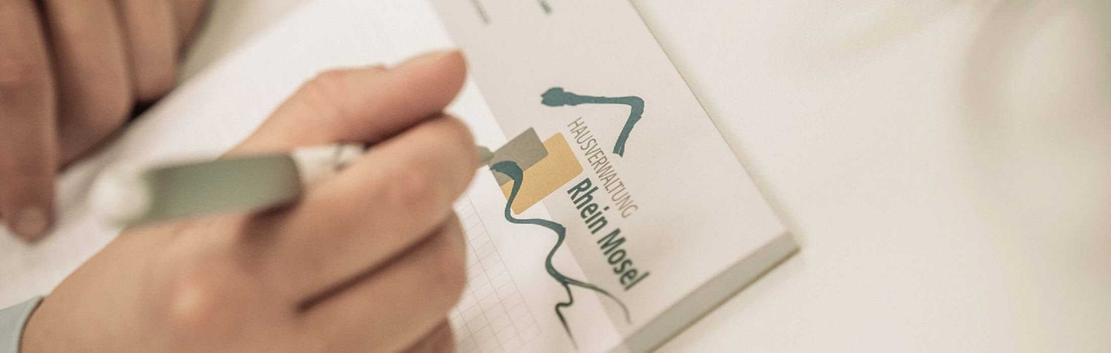 Foto, das eine Hand zeigt, die einen Kugelschreiber hält